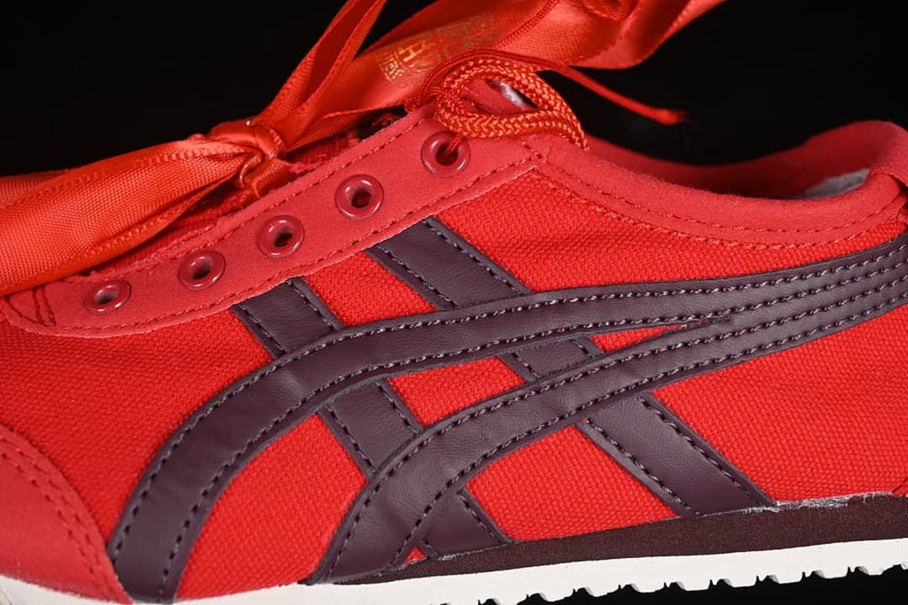 Close-up of the red upper, dark side stripes, eyelets and laces