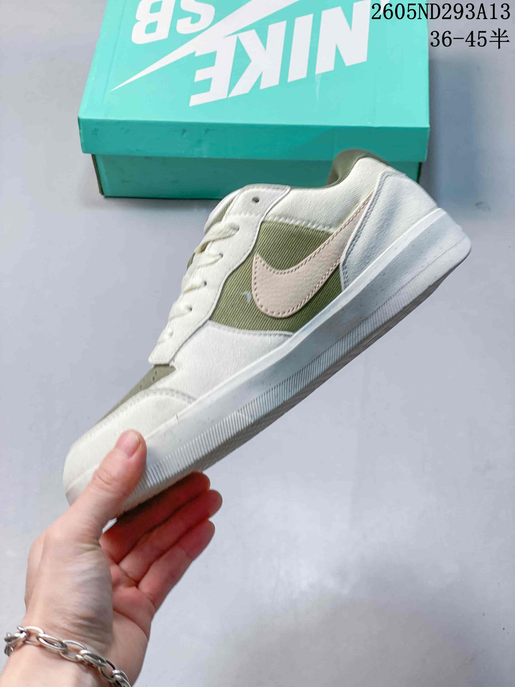 Side view of the low-top shoe, highlighting the olive panels and pale pink Swoosh.