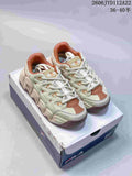 Pair of cream and rust FILA-style chunky sneakers shown on a shoebox