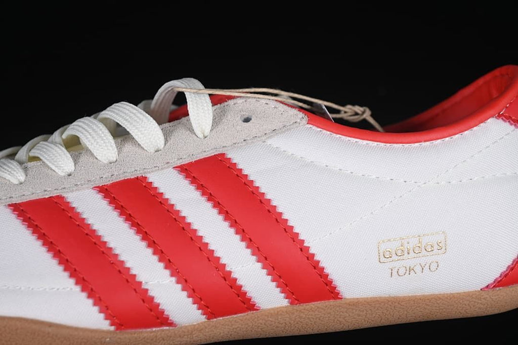 Close-up of the red side stripes, gray lacing overlay, and Tokyo side branding