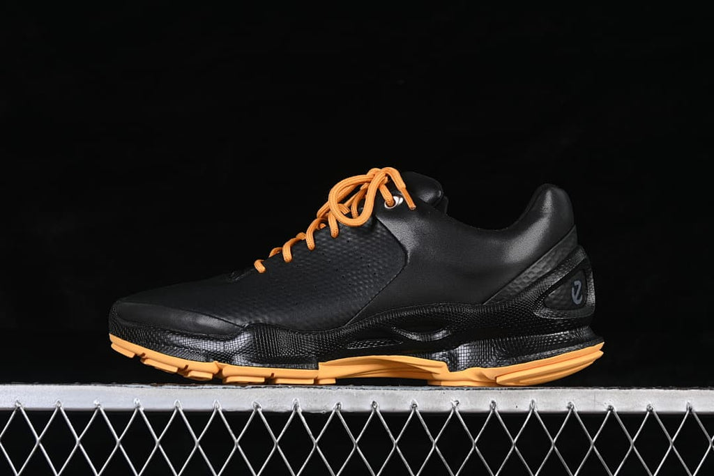 Angled view of the black ECCO BIOM shoe showing orange laces and sole