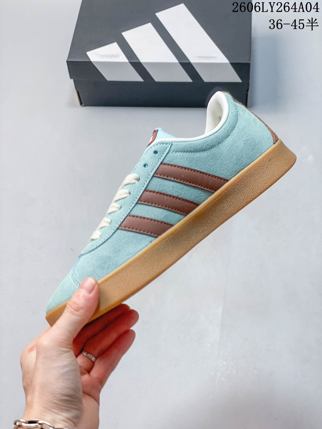 Side profile of the blue adidas VL Court Classic sneaker with brown stripes and gum-colored sole