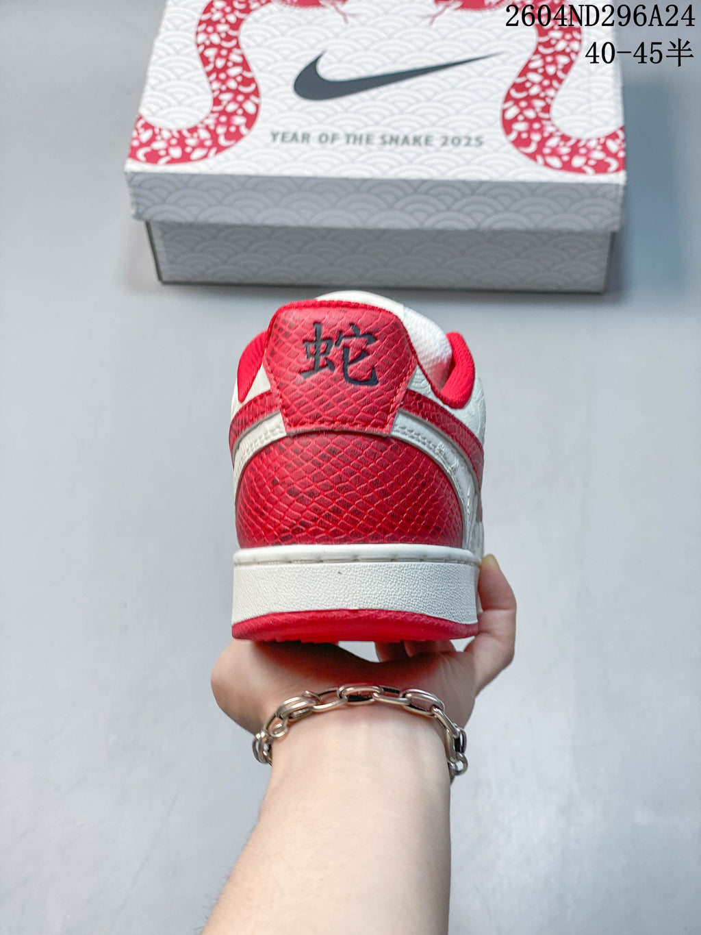 Rear view of the white and red sneaker with textured red heel panel