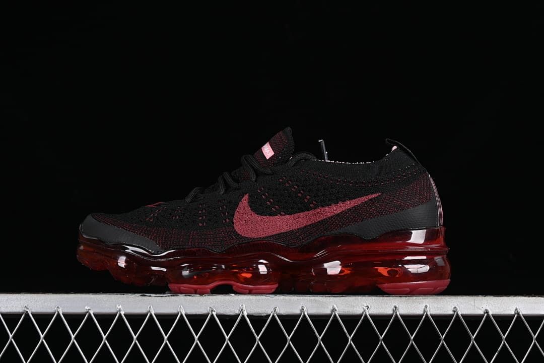 Side profile of the black and dark red sneaker with translucent red sole