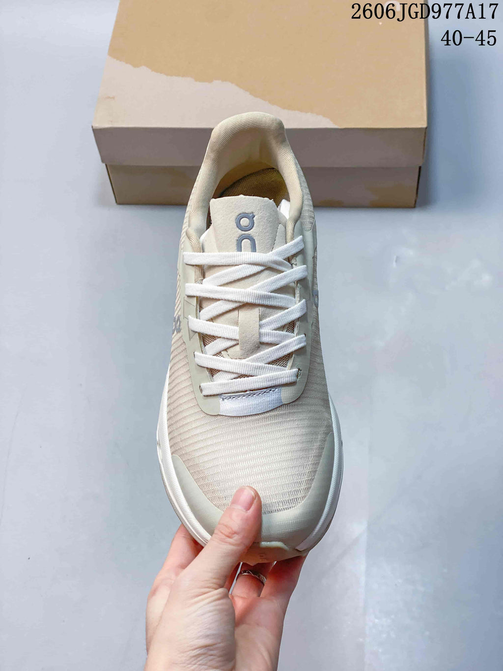 Top view of the beige shoe with white laces and a ribbed-looking upper.