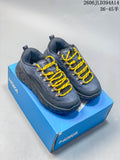 Pair of blue-gray HOKA low-top shoes with yellow laces on a blue shoe box.