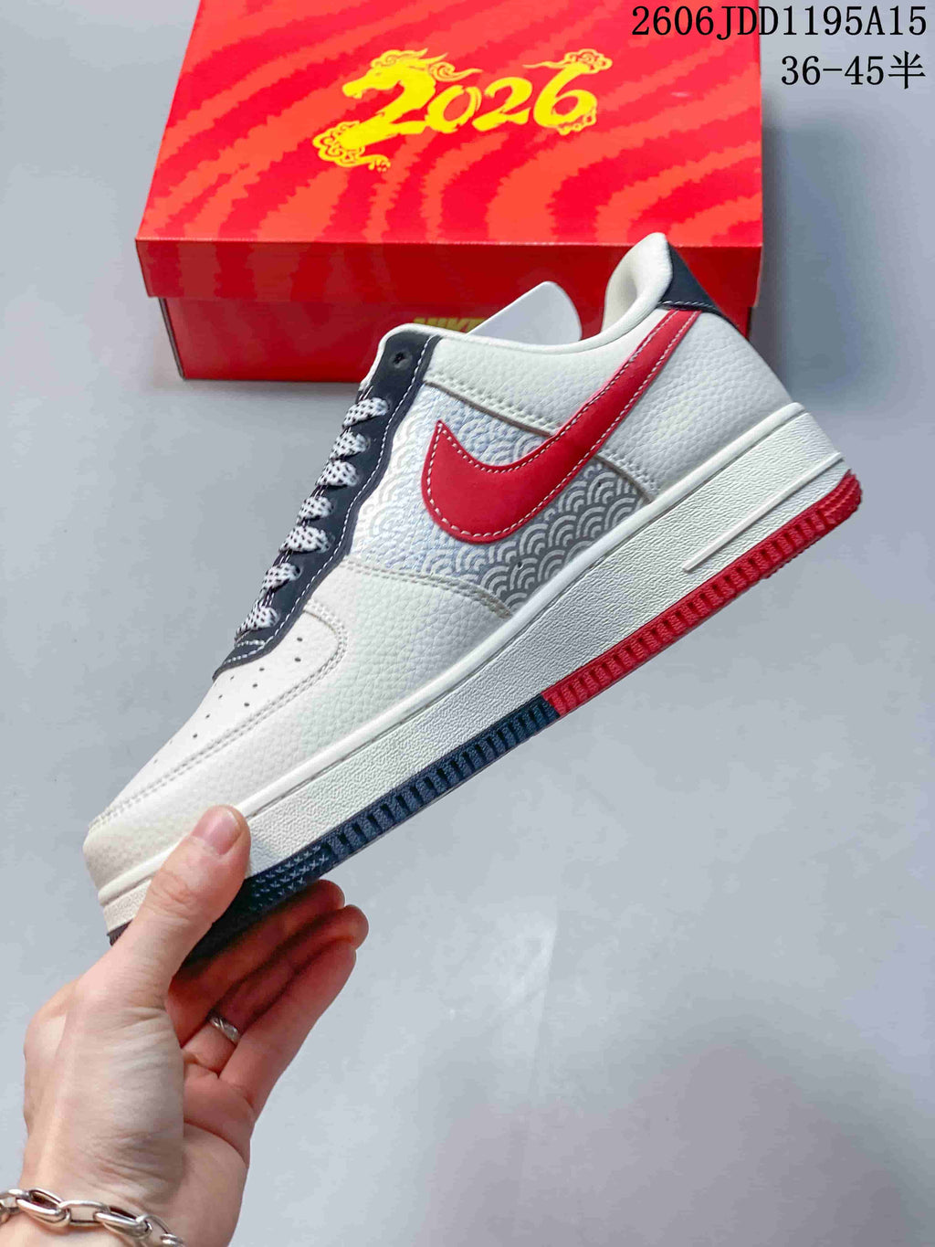 Side view of the white Air Force 1 Low with a red Swoosh, patterned panel and red outsole accents