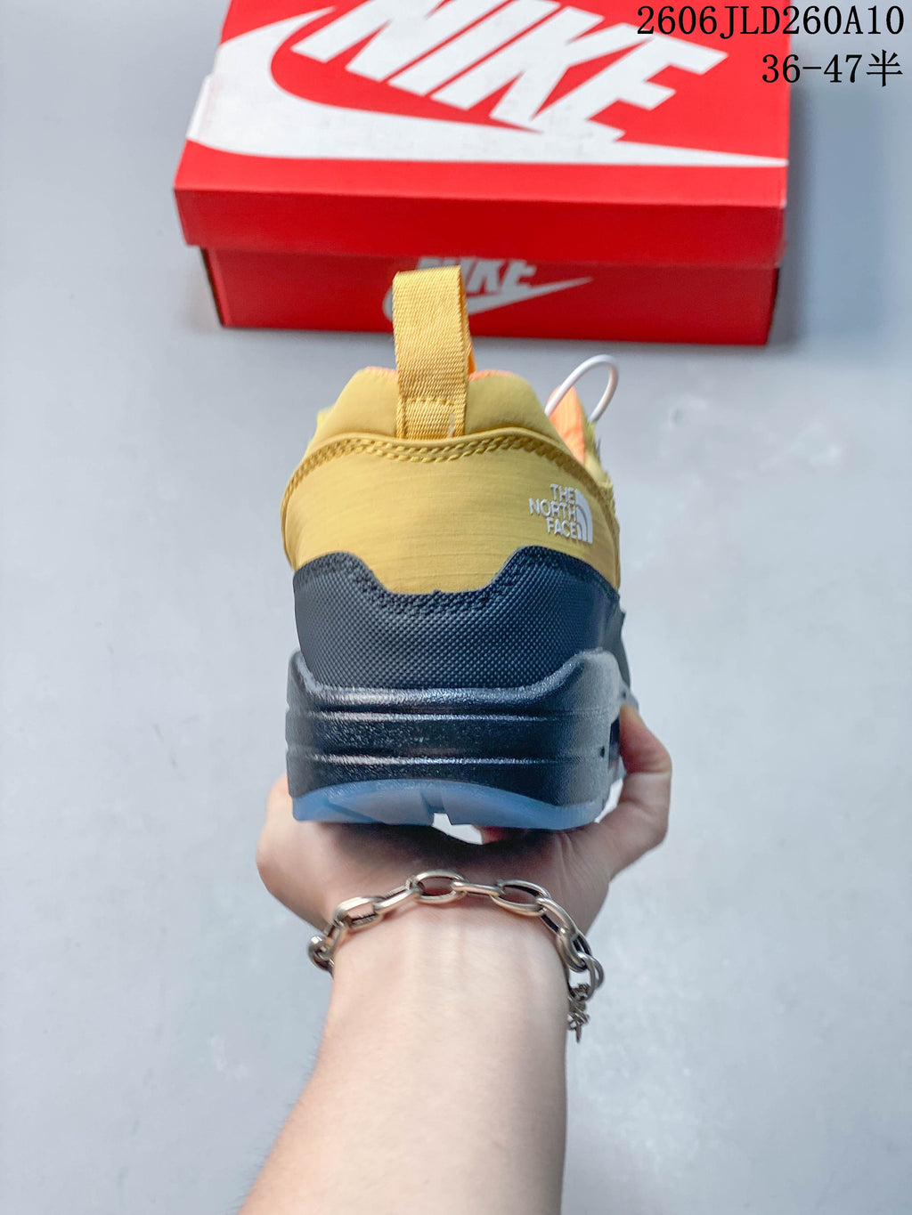 Rear view of the yellow and dark sneaker with heel pull tab