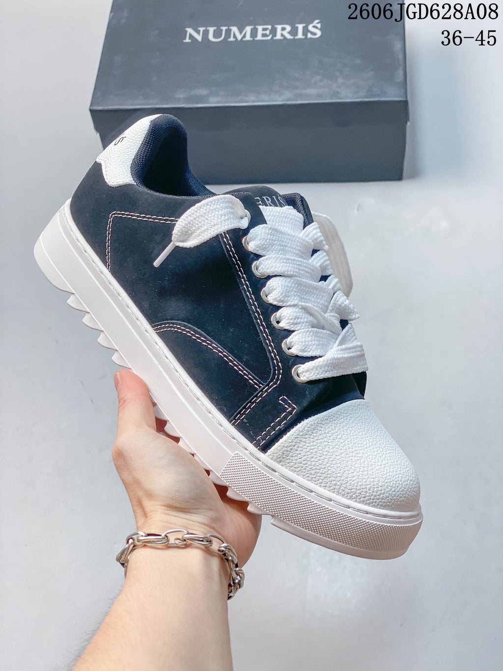 Dark navy sneaker with white contrast stitching, laces, toe panel, and sole.