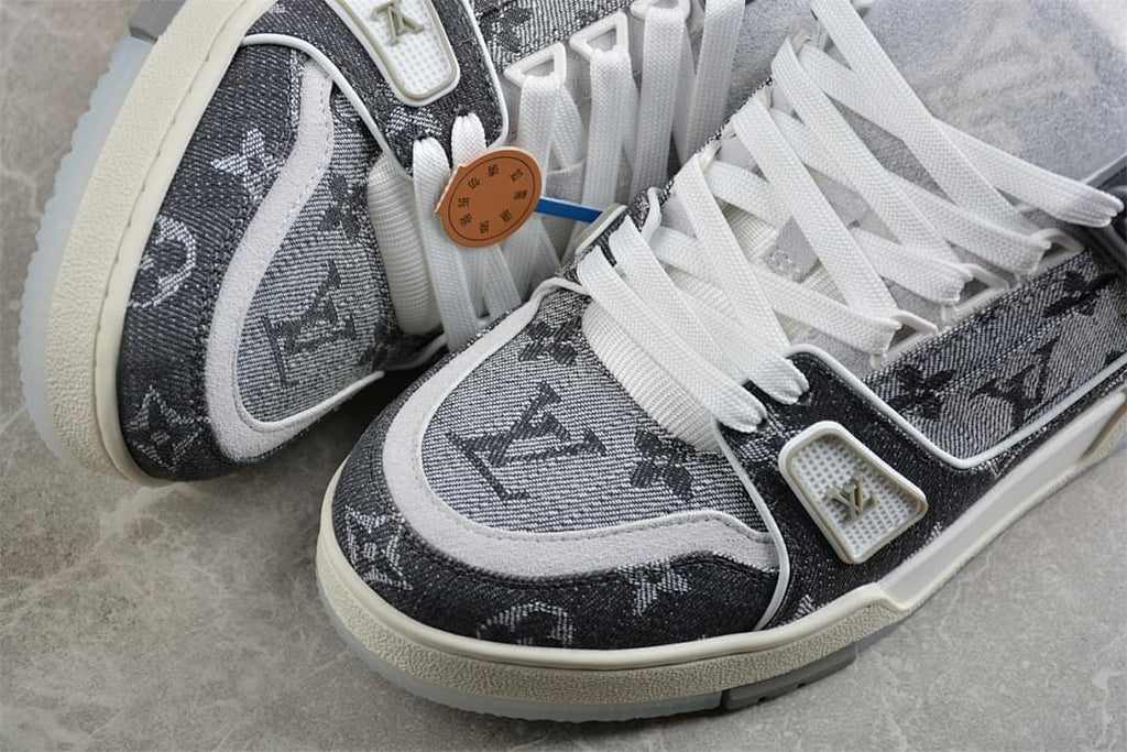 Close-up of the patterned toe, light trim, and lace area on the sneakers.