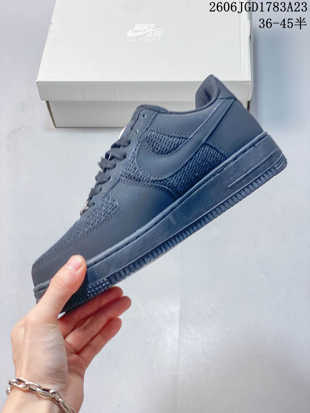 Side profile of a dark gray low-top sneaker with textured panels.