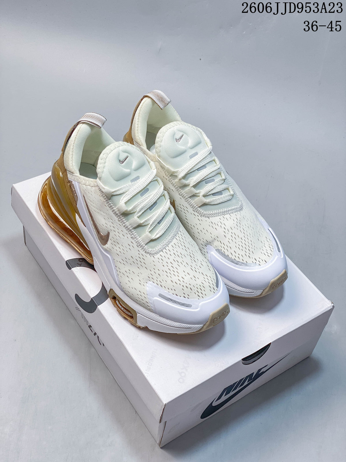 Pair of white and gold Nike Air Max 270 sneakers displayed on a shoebox