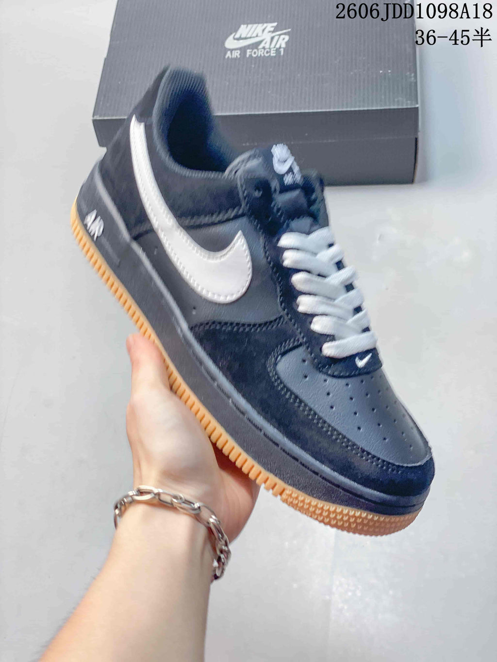 Side view of a navy and white low-top Air Force 1 sneaker with a gum-colored outsole.