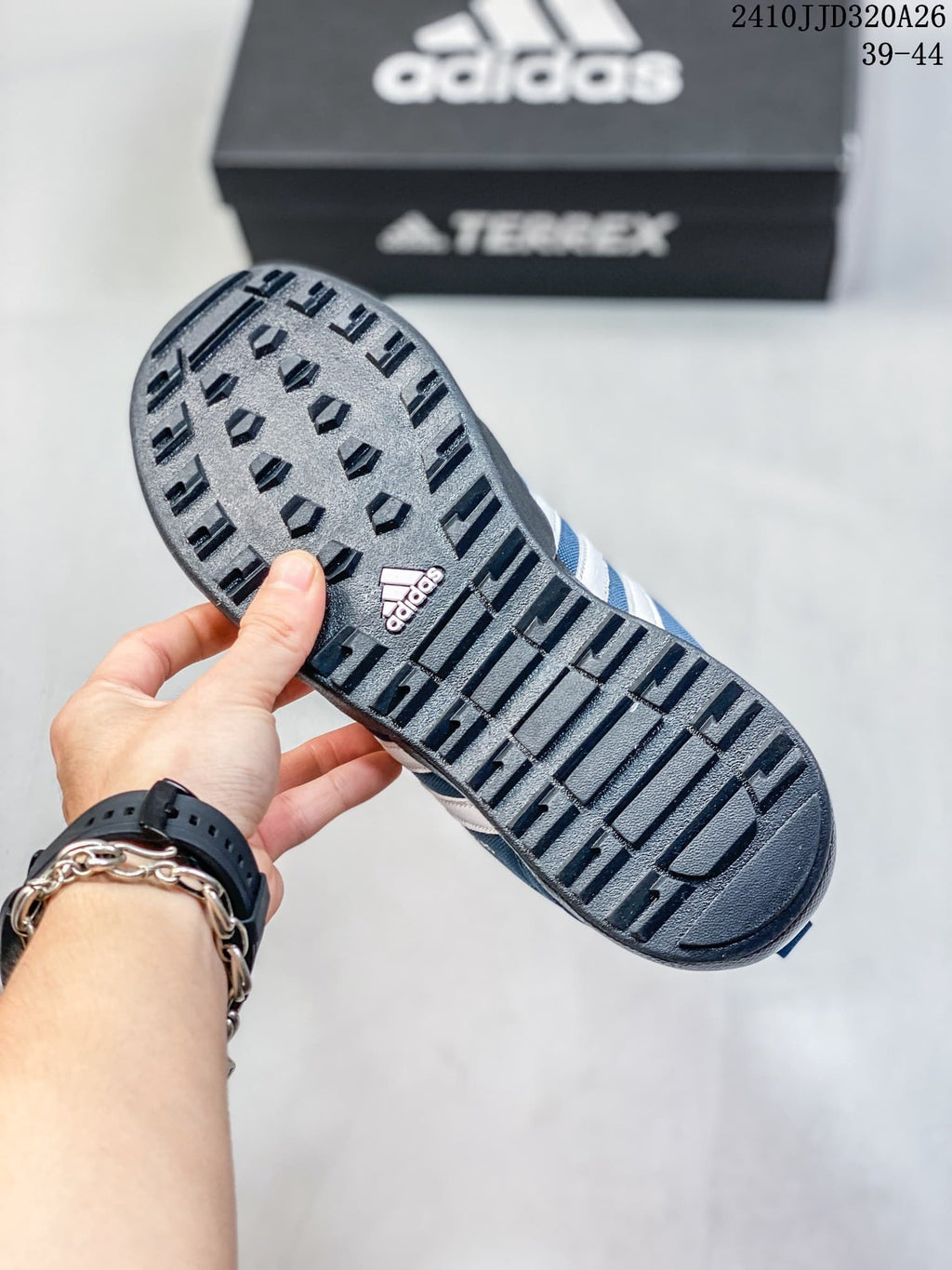 Close-up of the dark lugged outsole on a blue adidas Daroga Plus Canvas shoe.