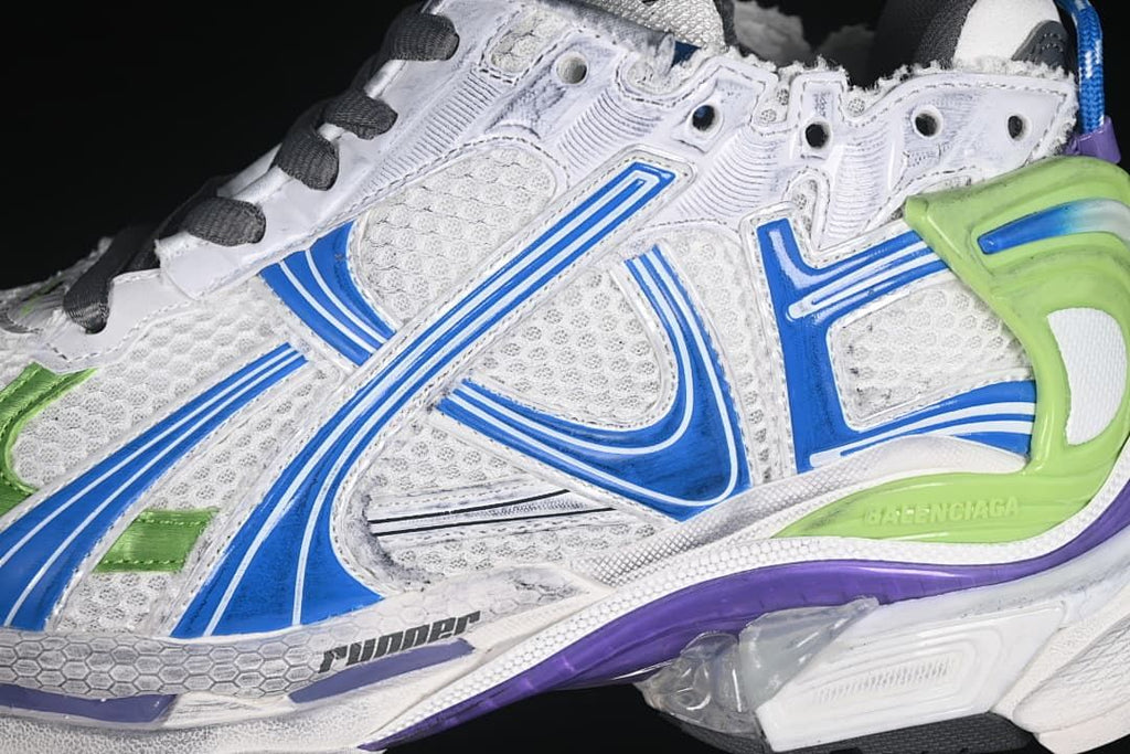 Close-up of the sneaker's blue side detailing, mesh-like panels, and green heel support