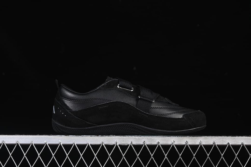 Side profile of the black sneaker with its strap closure
