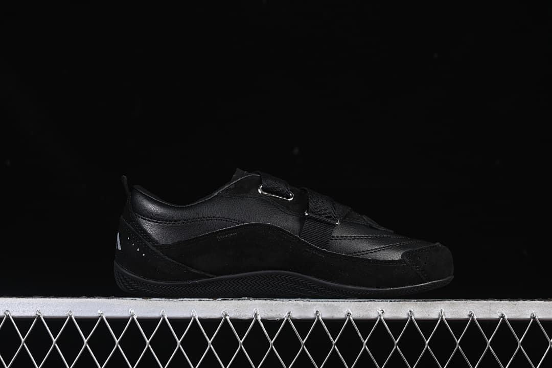 Side profile of the black sneaker with its strap closure
