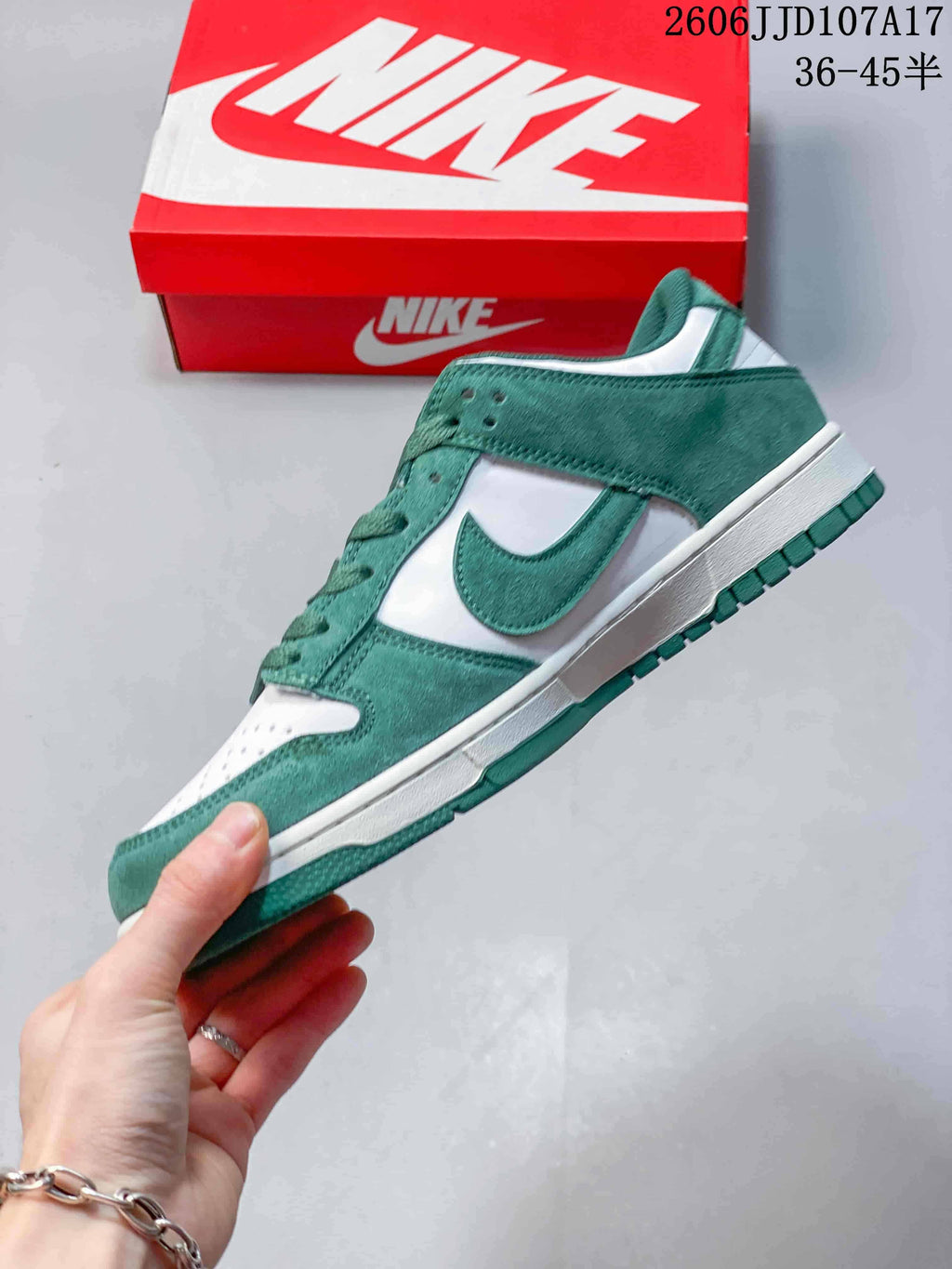 Side view of a green and white low-top sneaker with a Swoosh