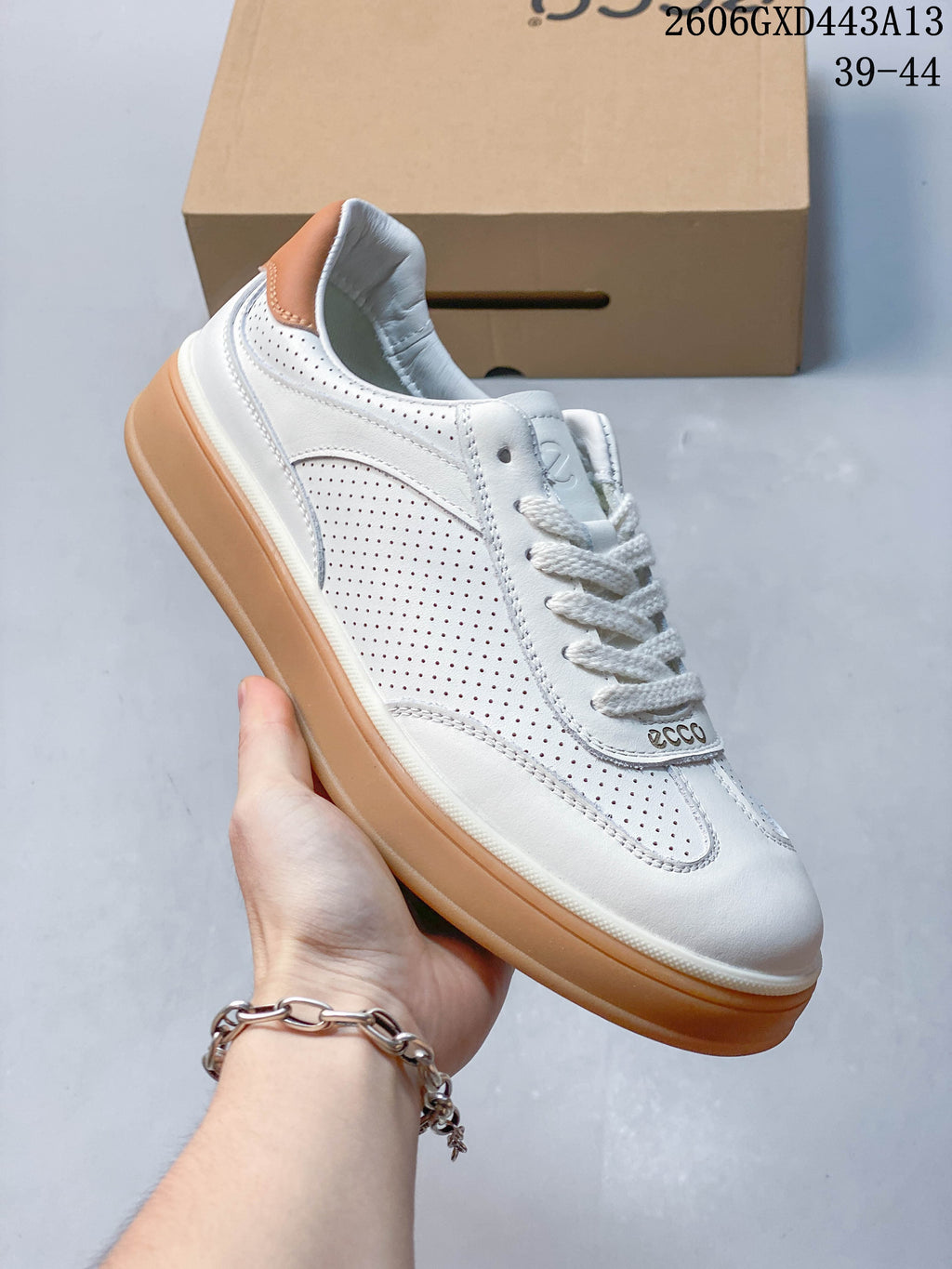 Angled side view of the white ECCO sneaker with perforated panels and tan accents.