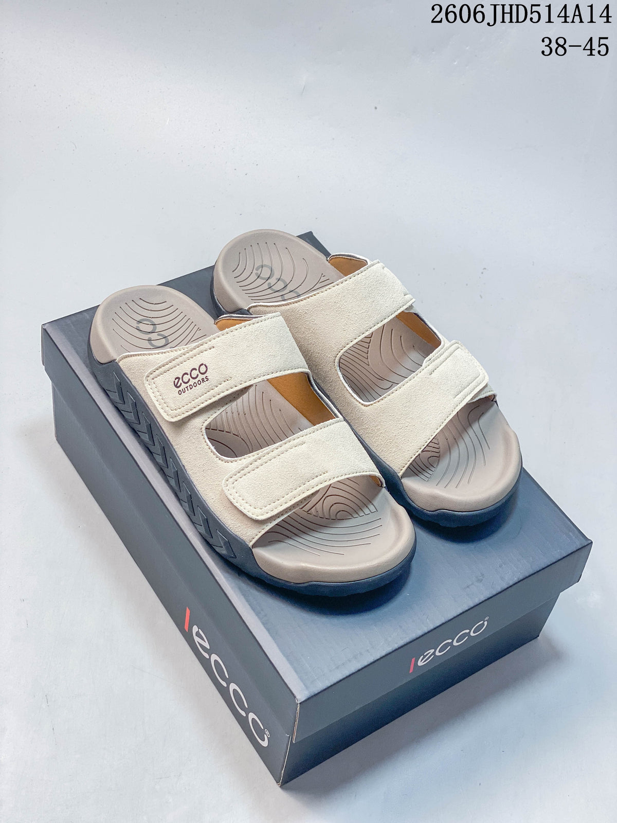 Pair of cream-colored two-strap sandals on a box, shown from above.