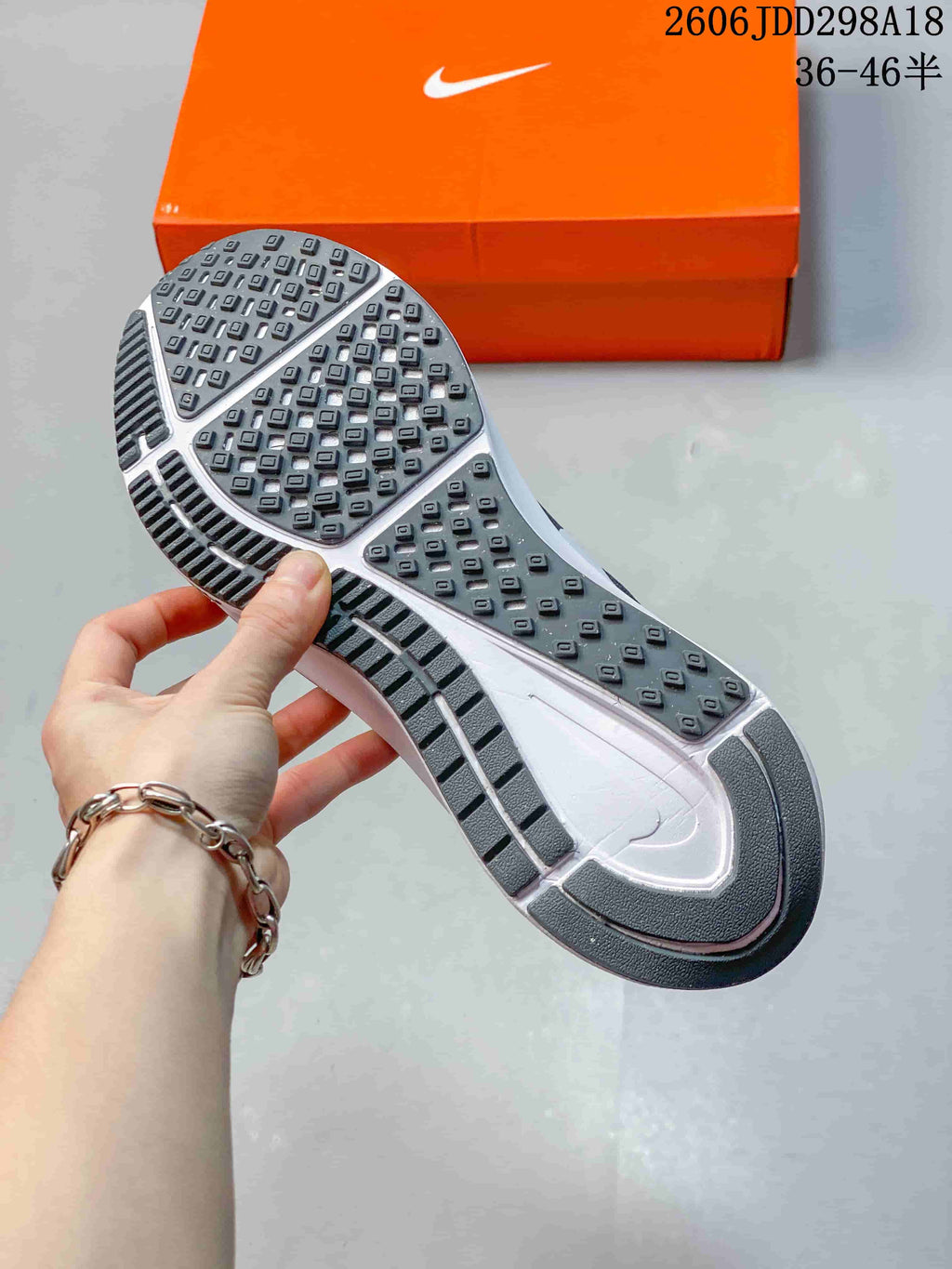 Underside of the gray running shoe showing its patterned outsole