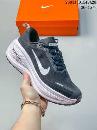 Dark gray Nike Vomero Plus shoe with a white swoosh and light-colored layered sole.