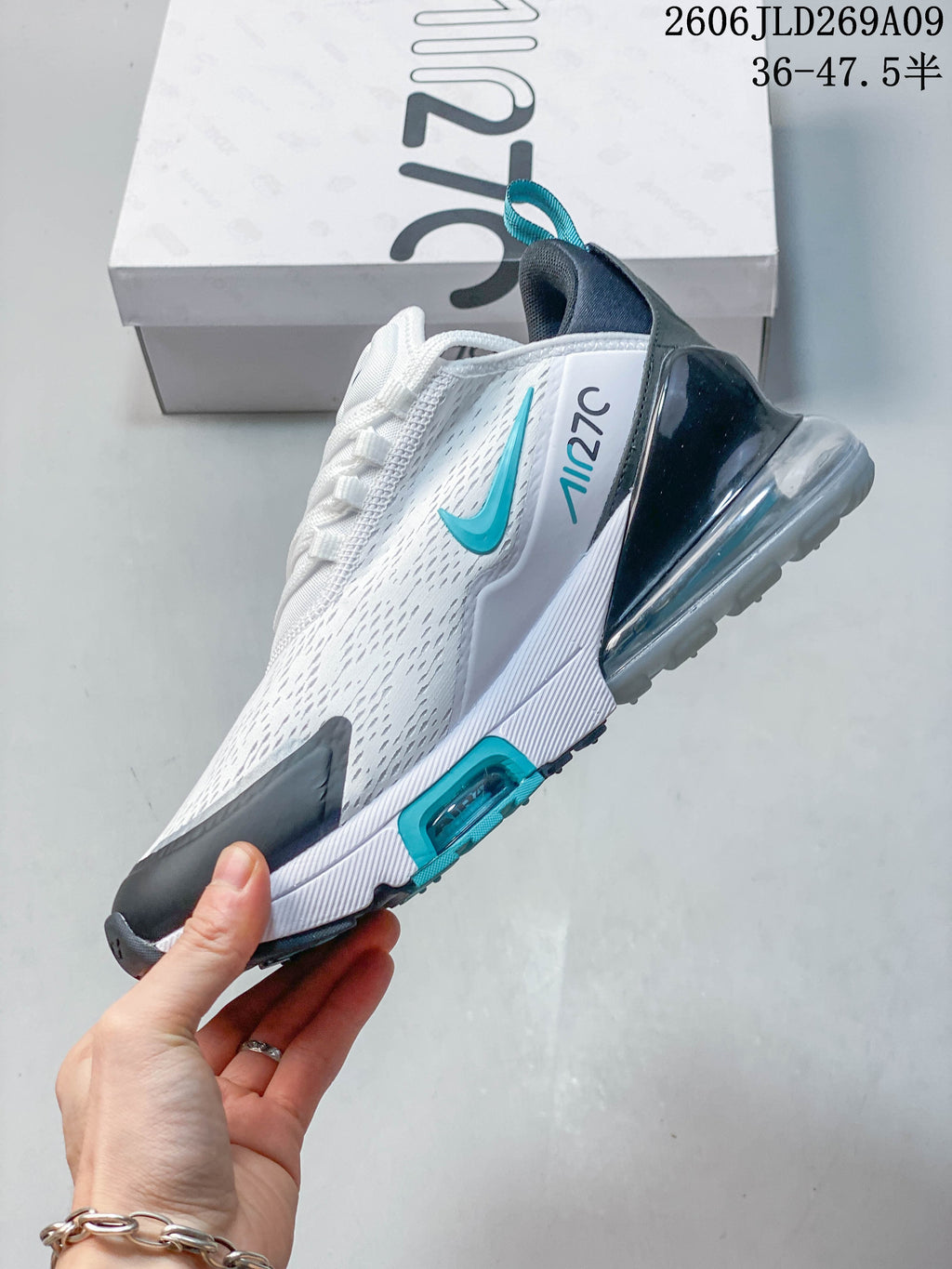 Side view of a white Nike Air Max 270 sneaker with teal details and a visible heel unit
