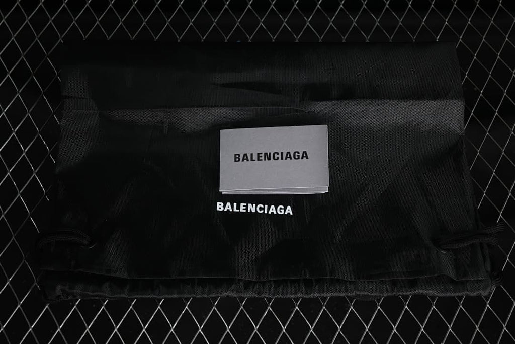Black branded fabric bag and printed card pictured with the sneakers.