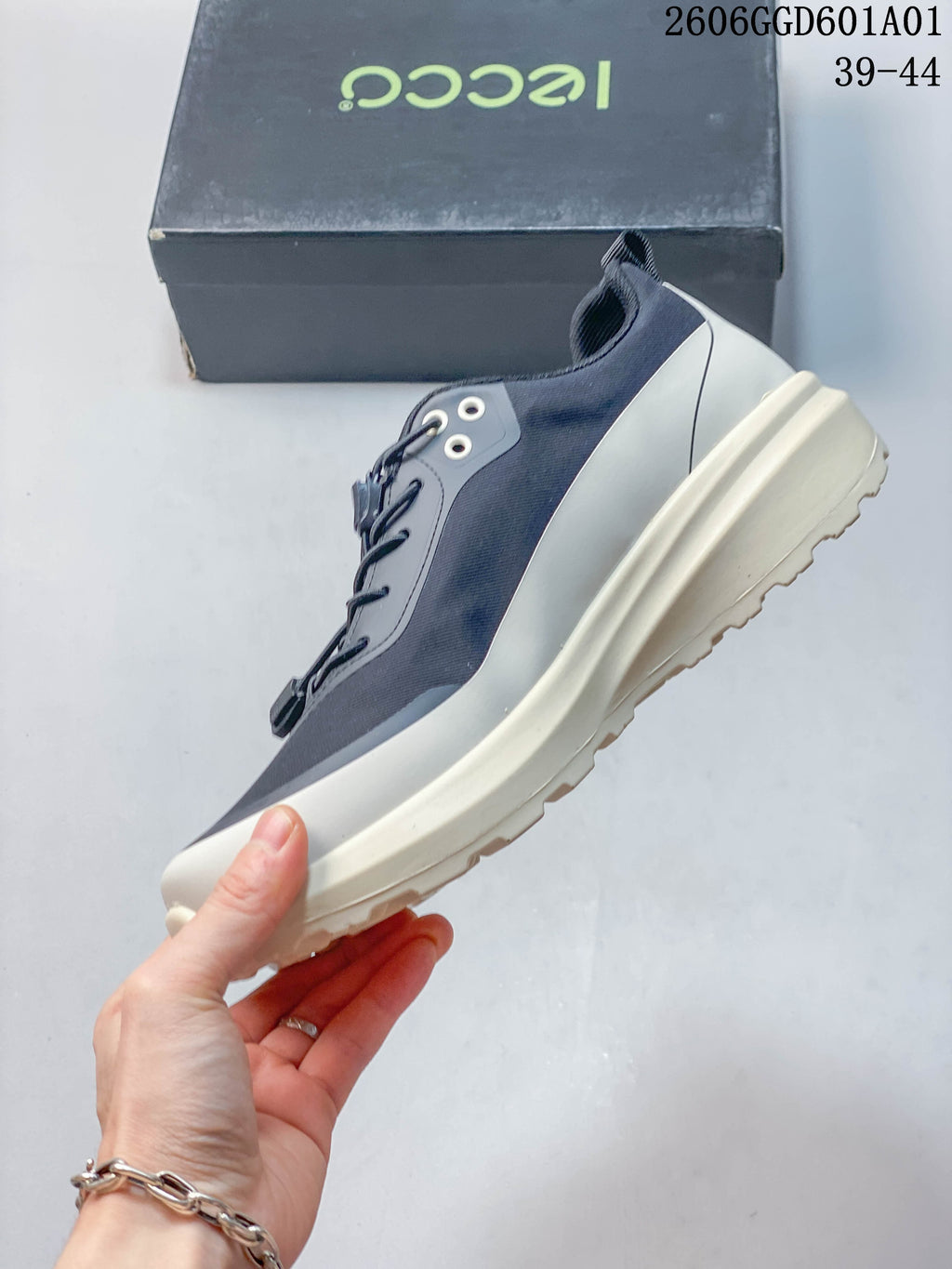 Side profile of the navy and grey sneaker with off-white sole