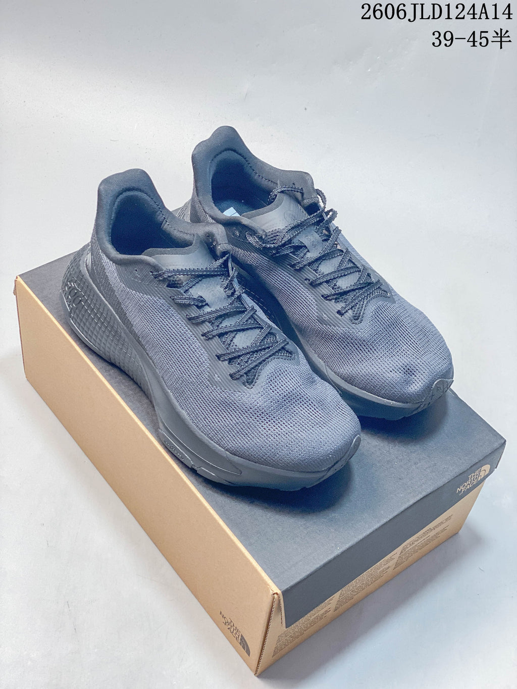 Pair of gray The North Face trail running shoes displayed on a shoebox.