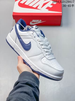 White low-top Nike sneaker with blue Swoosh accents held above a red Nike shoe box; overlay text shows style 2604JGD129A17 and size range 36-45.