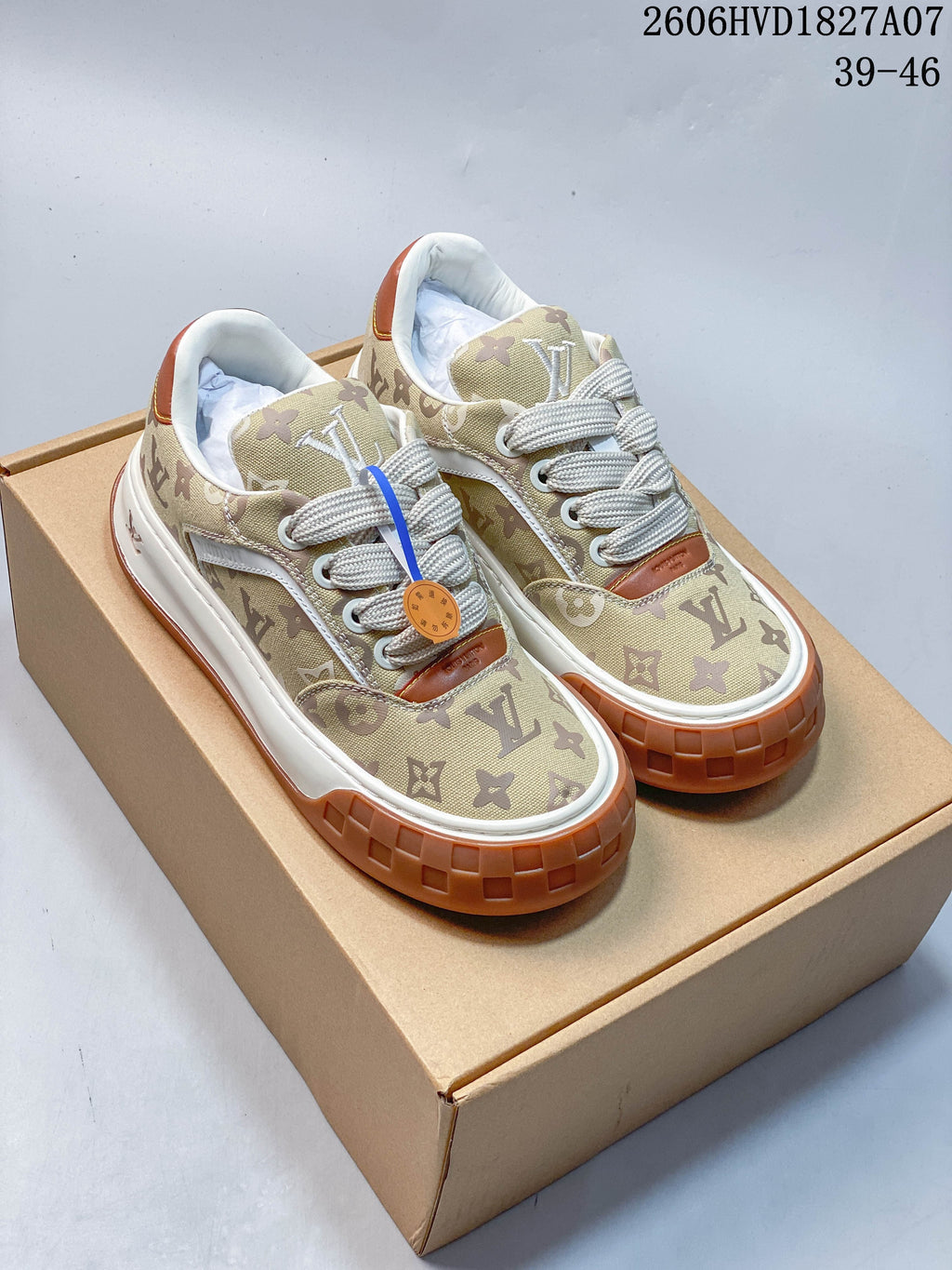 Pair of beige monogram low-top sneakers with cream laces, white midsoles, and gum-brown outsoles.