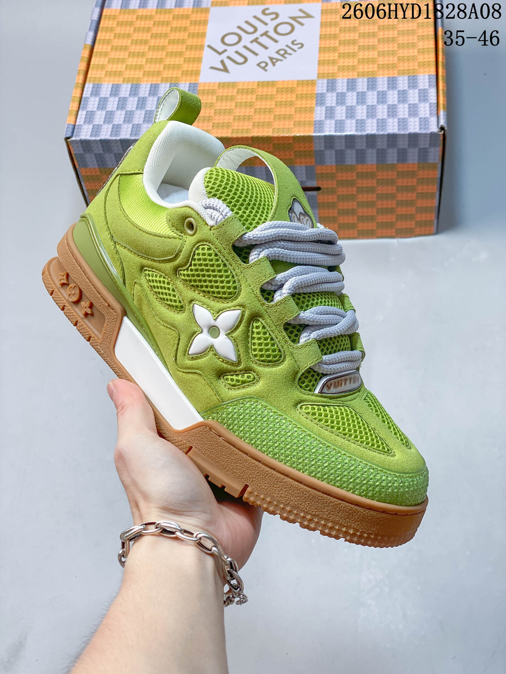 Close-up of a lime green low-top sneaker with mesh panels, thick laces, side emblem, and gum-style outsole.