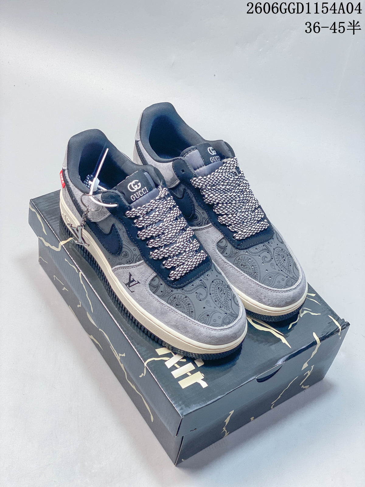 Pair of grey and navy low-top sneakers with paisley panels and a metal-tone charm