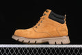 Side view of a wheat-colored CAT mid-top boot with black padded collar and lugged outsole