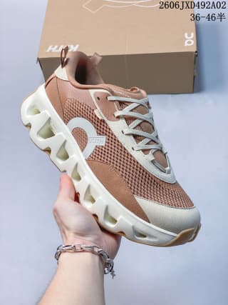 Angled front view of the sneaker with contrasting panels, laces, pull tabs, and a rounded toe.