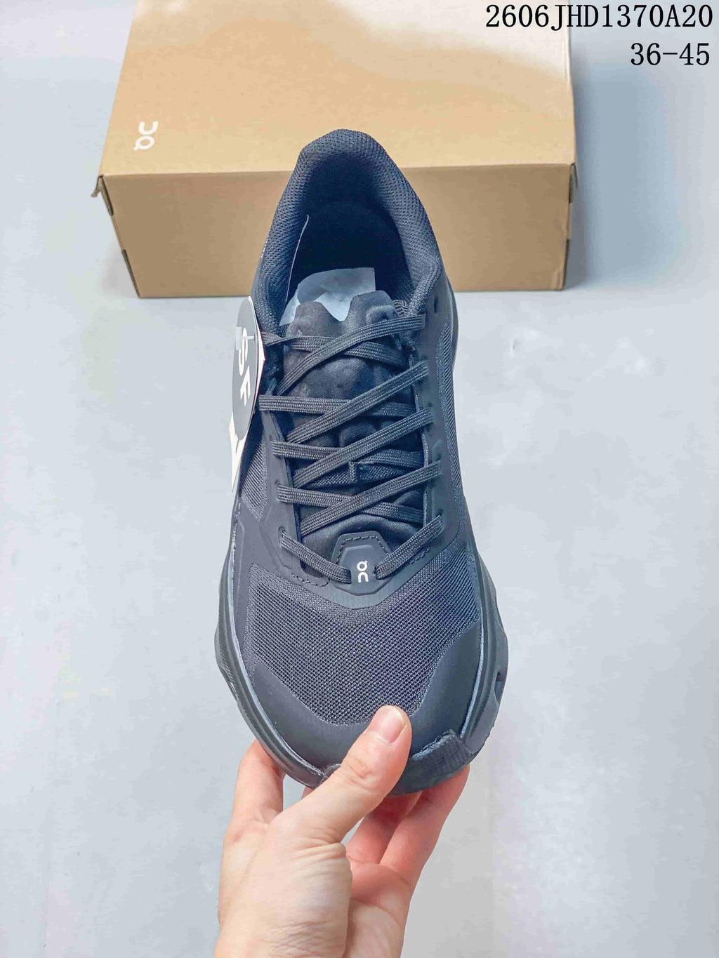 Top view of a charcoal gray sneaker showing its laces and mesh-like toe area.