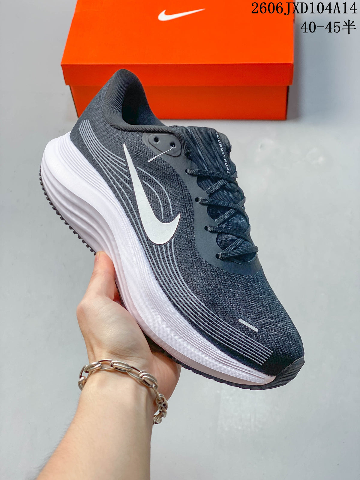 Close-up side view of a dark gray Nike Journey Run running shoe with a white Swoosh and thick white midsole.