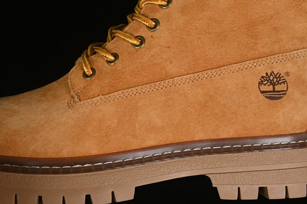 Close-up of the boot's side logo, stitching, and lugged sole