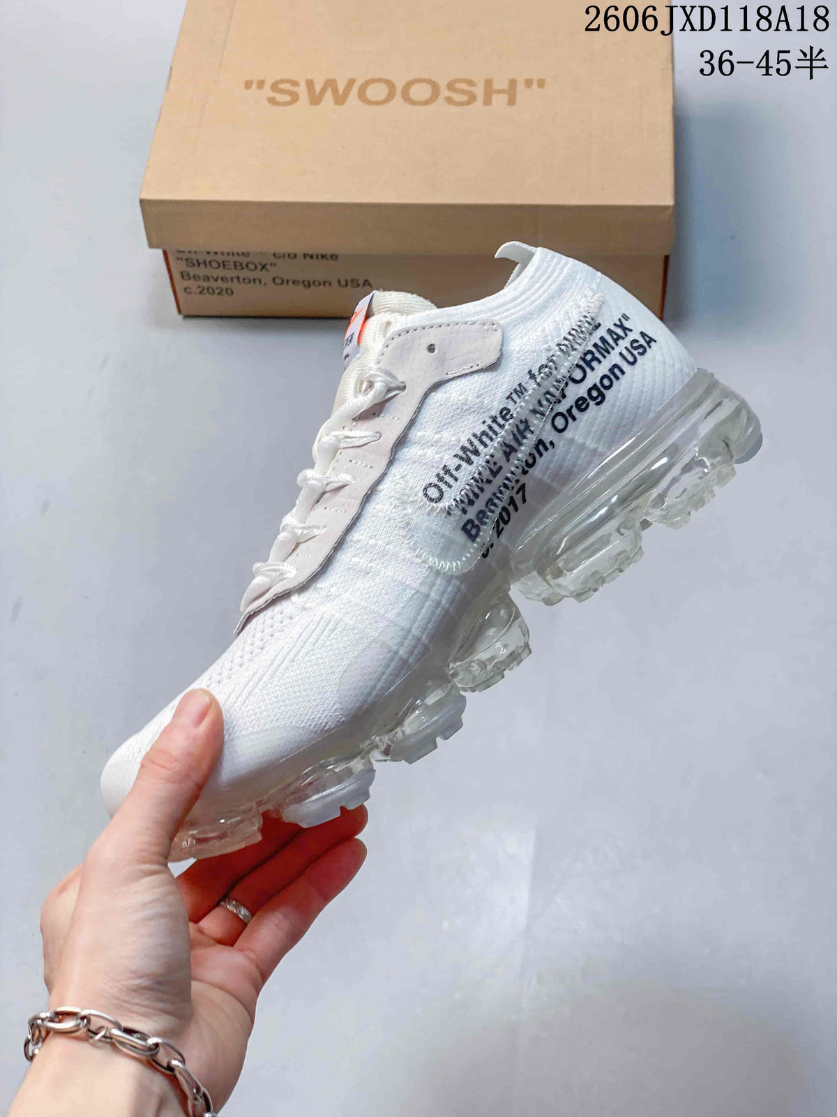 Side view of a white sneaker with printed text and a clear segmented sole