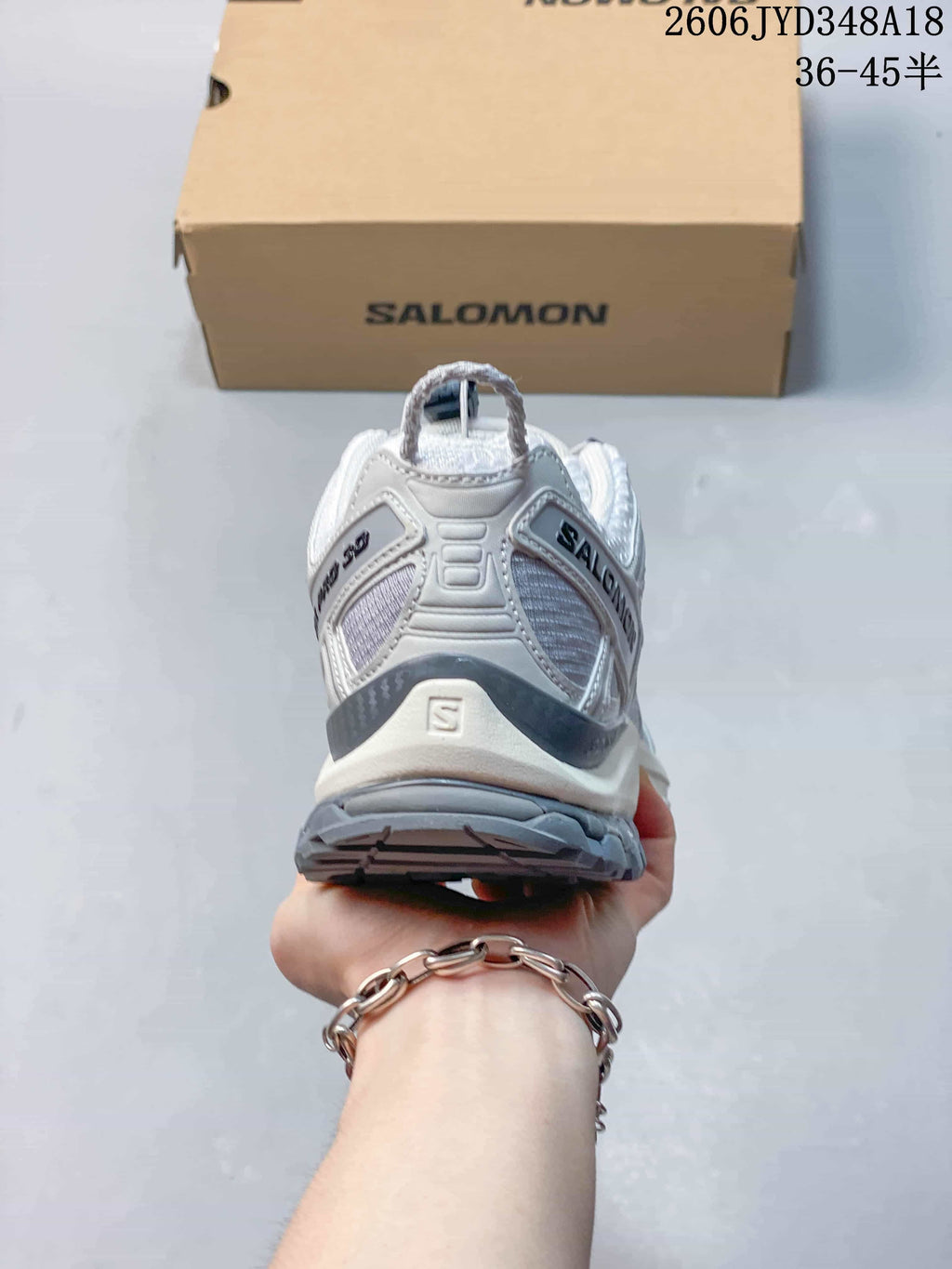 Rear view of the white and gray Salomon trail running shoe.