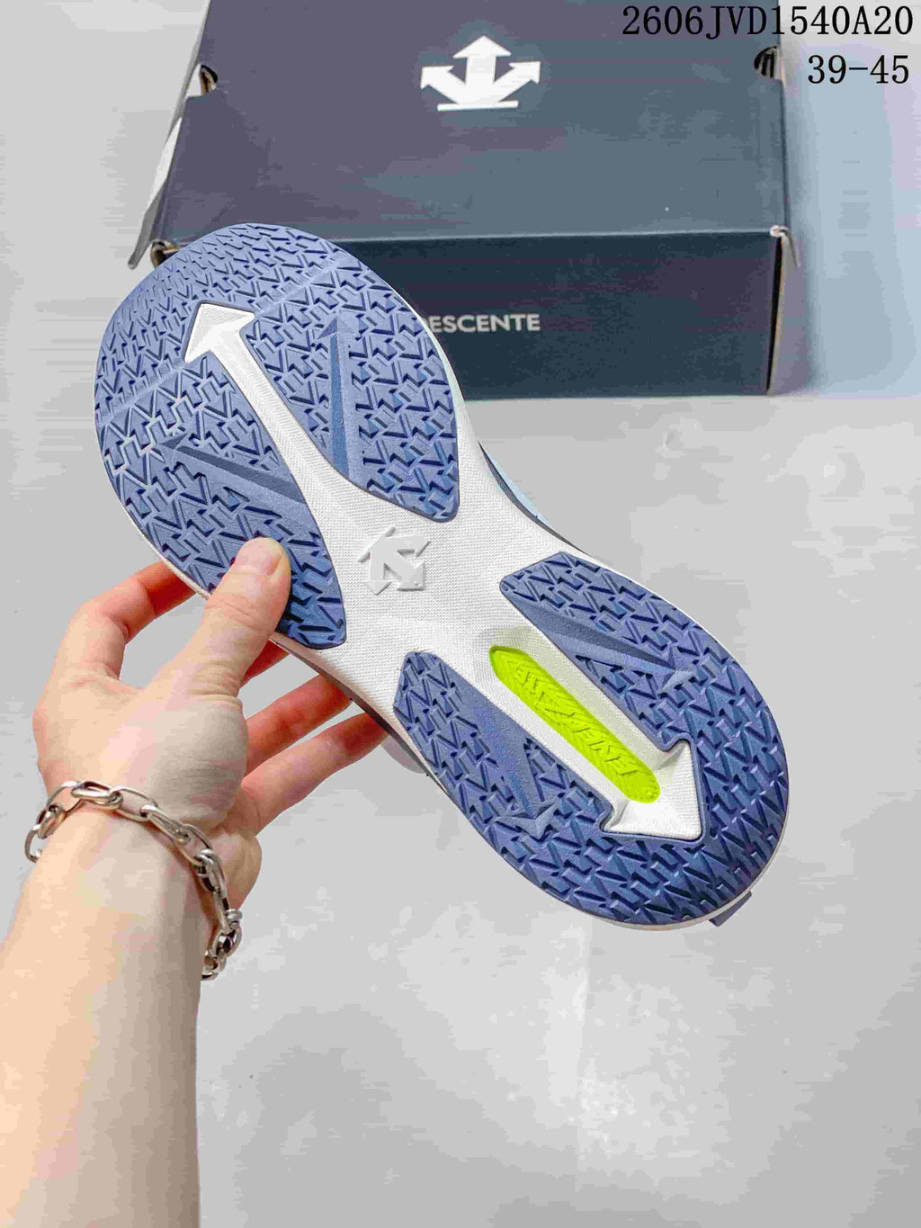Close-up of the sneaker outsole showing patterned blue-violet tread and a bright accent section