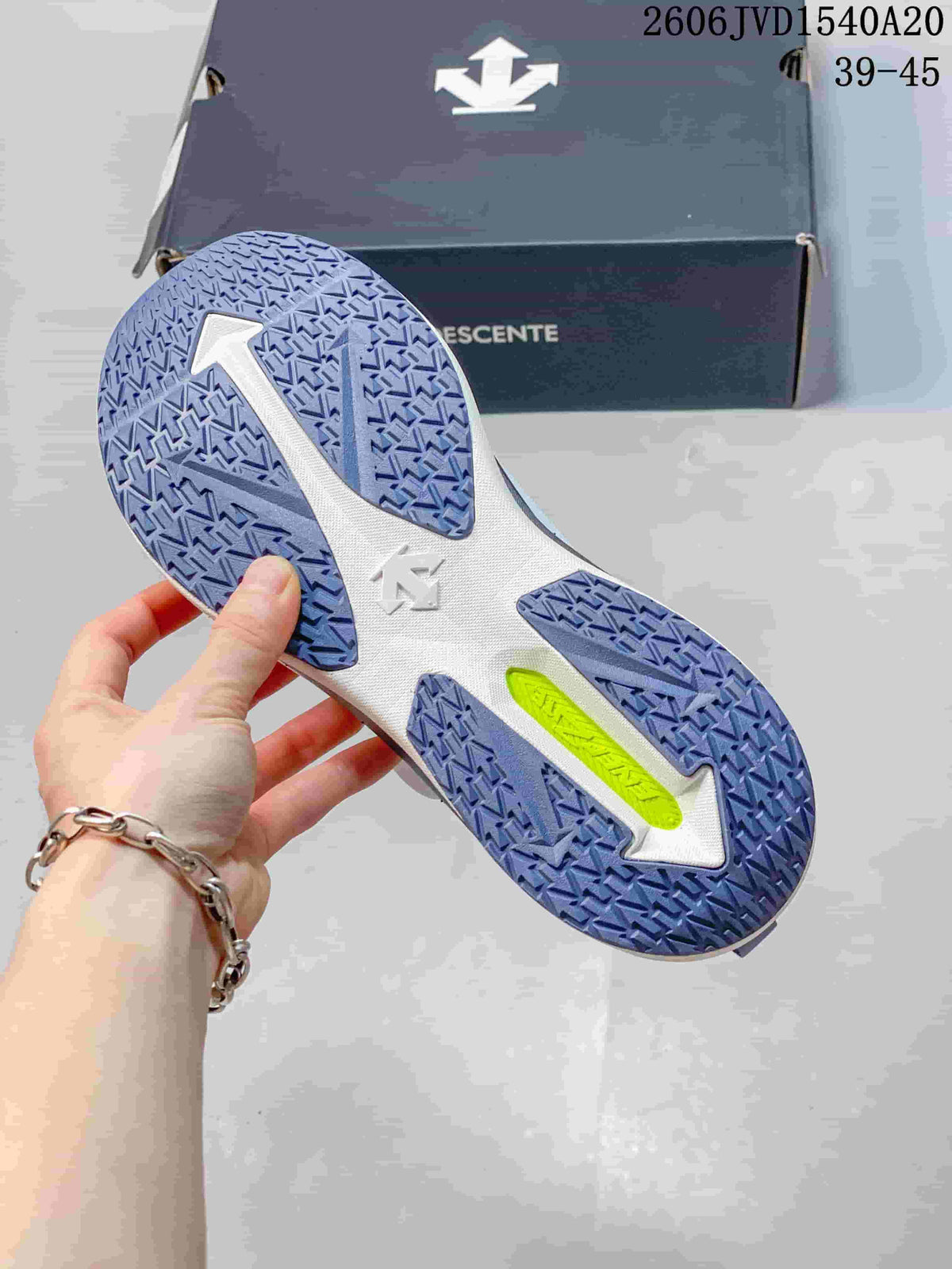 Close-up of the sneaker outsole showing patterned blue-violet tread and a bright accent section