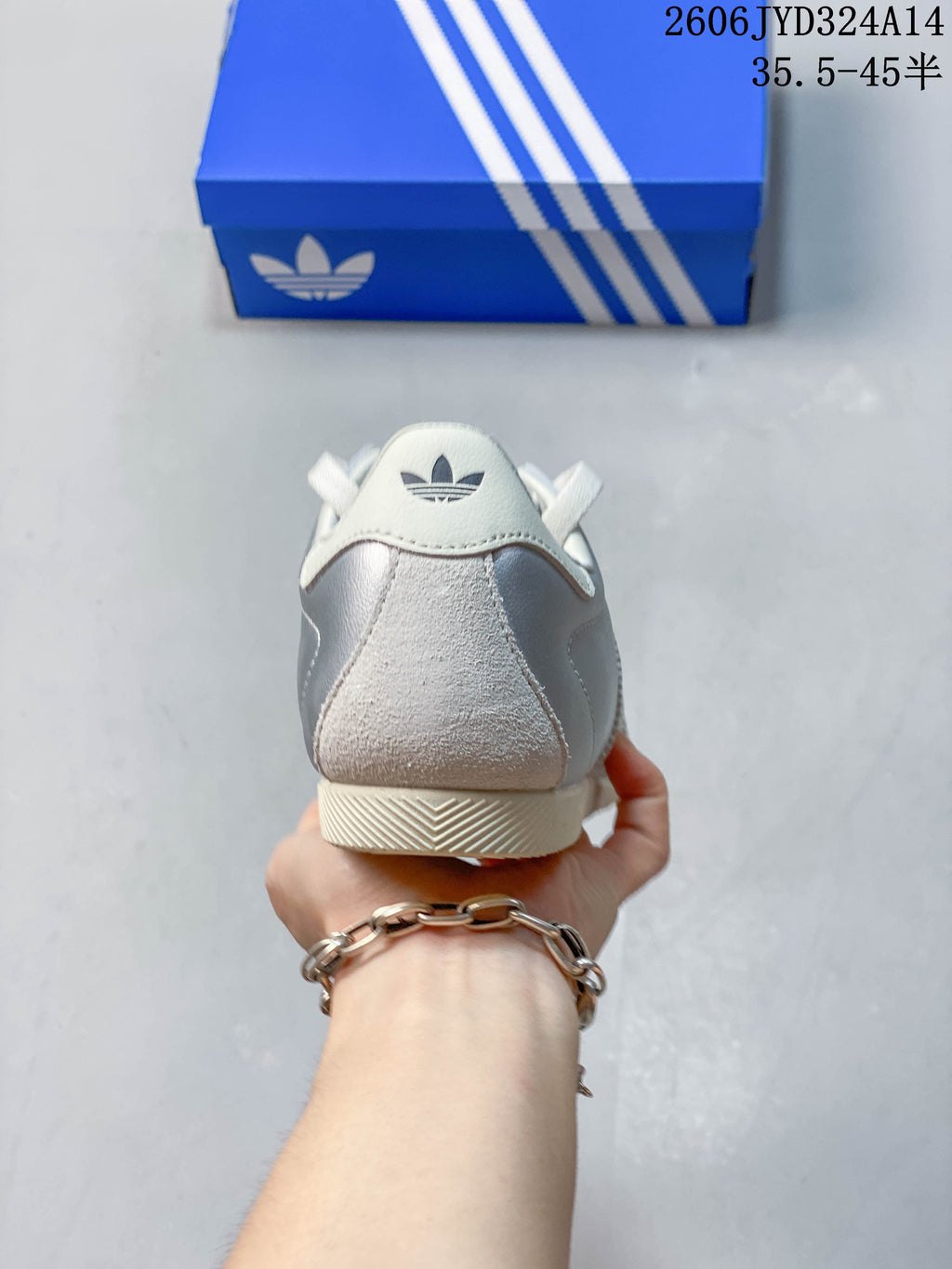 Rear view showing the heel details of a silver Adidas CHANGLE sneaker