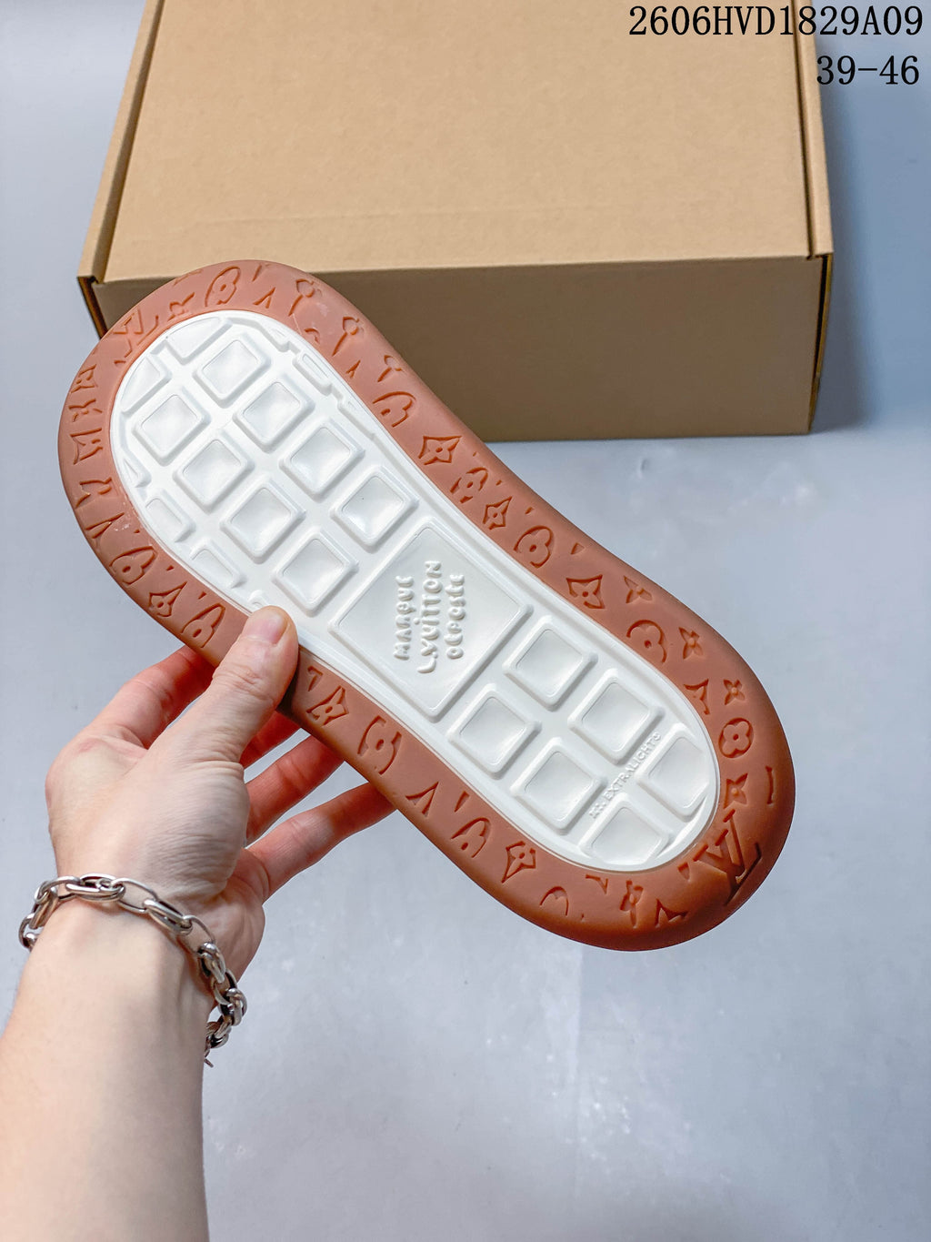 Underside of sneaker showing a white tread center and patterned brown outsole