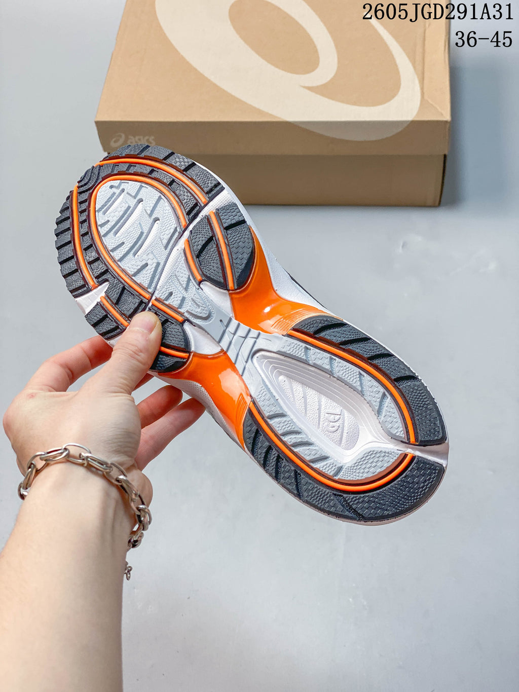 Underside of the sneaker showing a gray and orange patterned outsole.