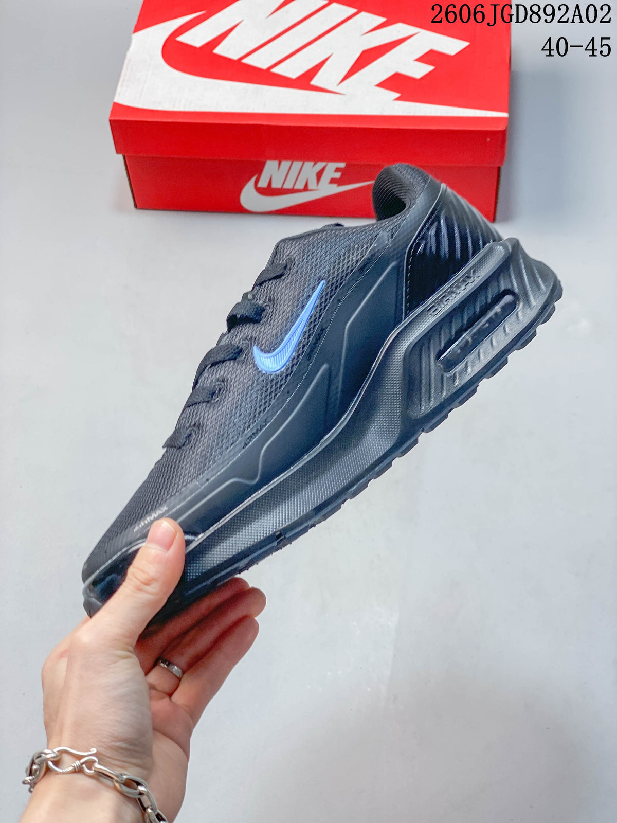 Side view of a dark gray Nike Air Max BIA shoe with blue Swoosh accent