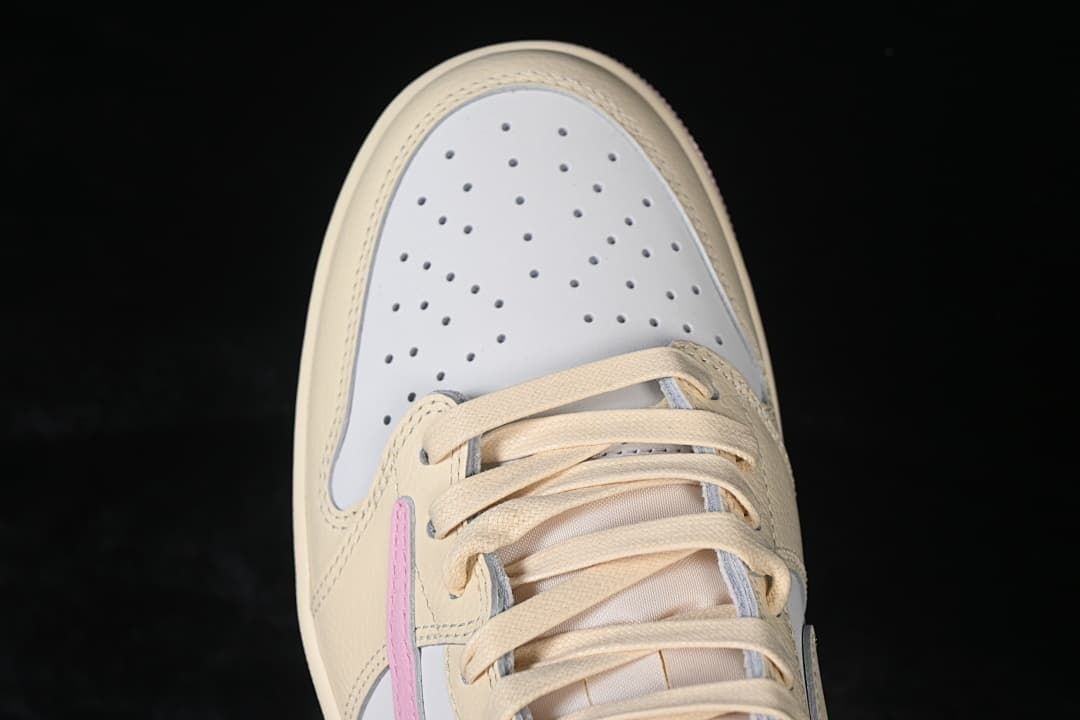 Top-down view of the perforated white toe box and cream laces
