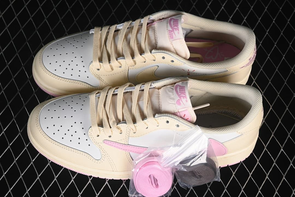 Pair of cream and white low-top sneakers with pink accents and spare laces