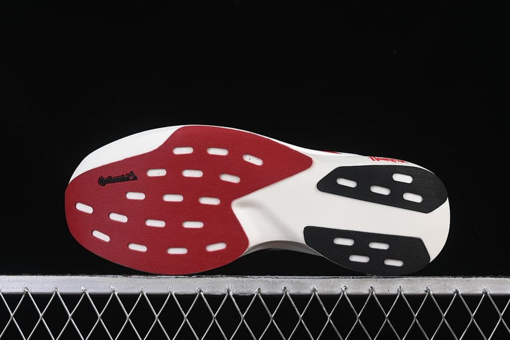 Outsole view with red, white, and black sections